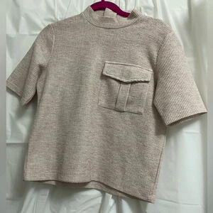 Reserved mesh and knit mock turtleneck shirt with front pocket and back zipper.